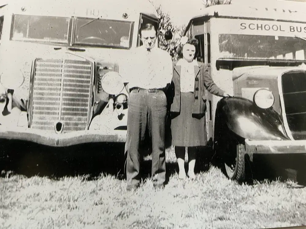 John & Catherine in front of two school buses