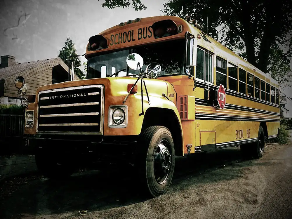 Vintage 1980s school bus parked near house